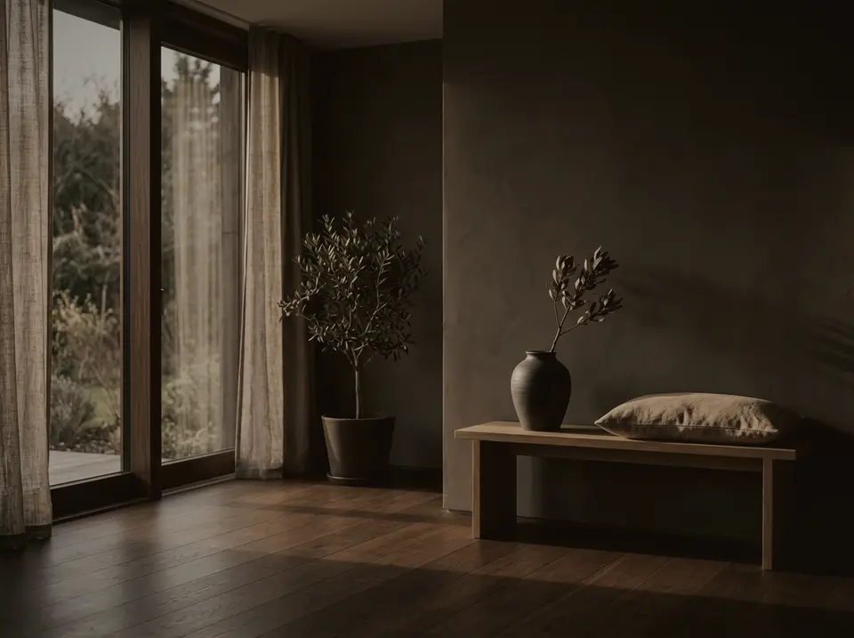 Minimalistisch eingerichteter Raum mit Holzbank und Pflanze im Abendlicht